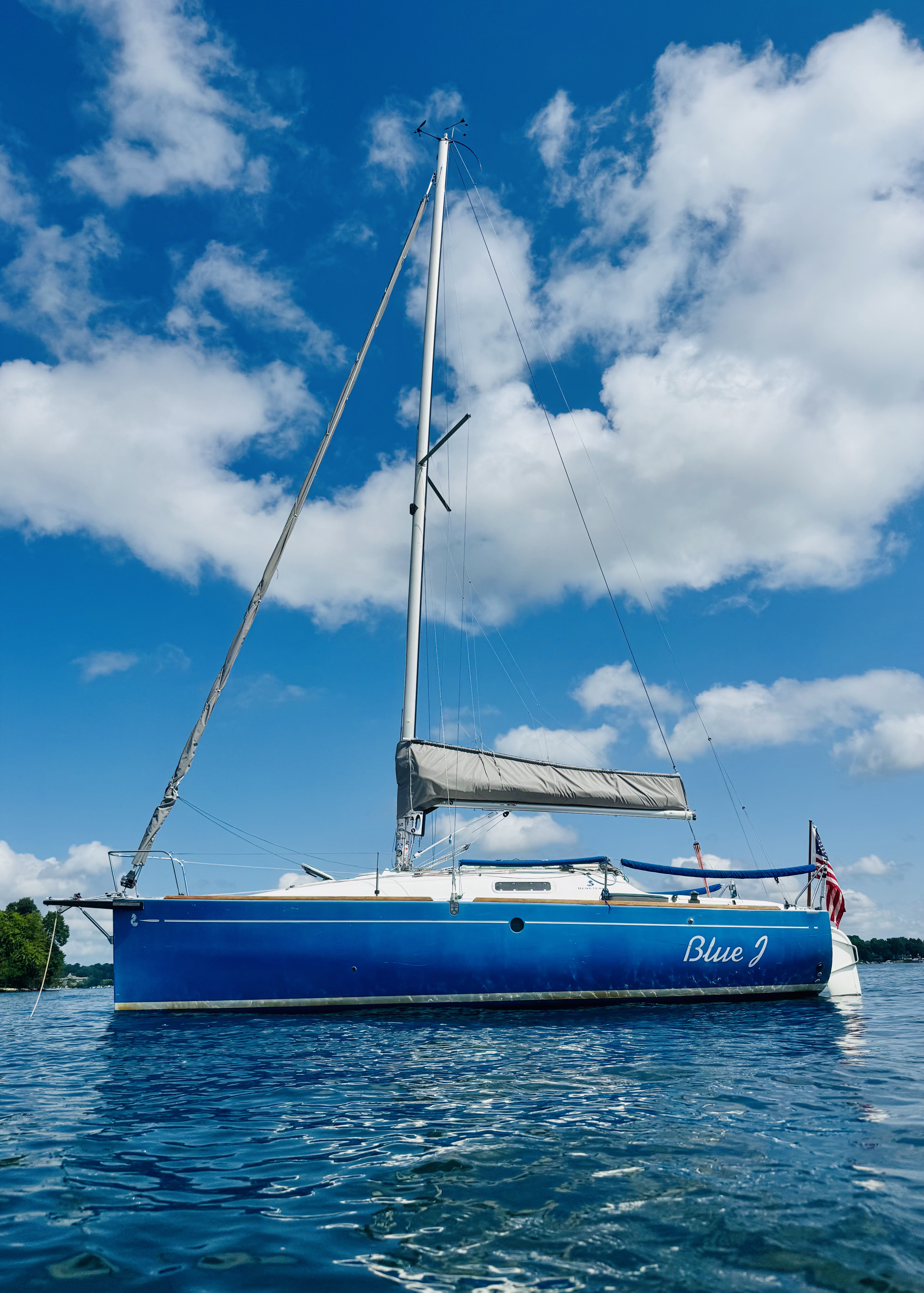 BlueJ sailboat at anchor on Lake Minnetonka with mainsail furled