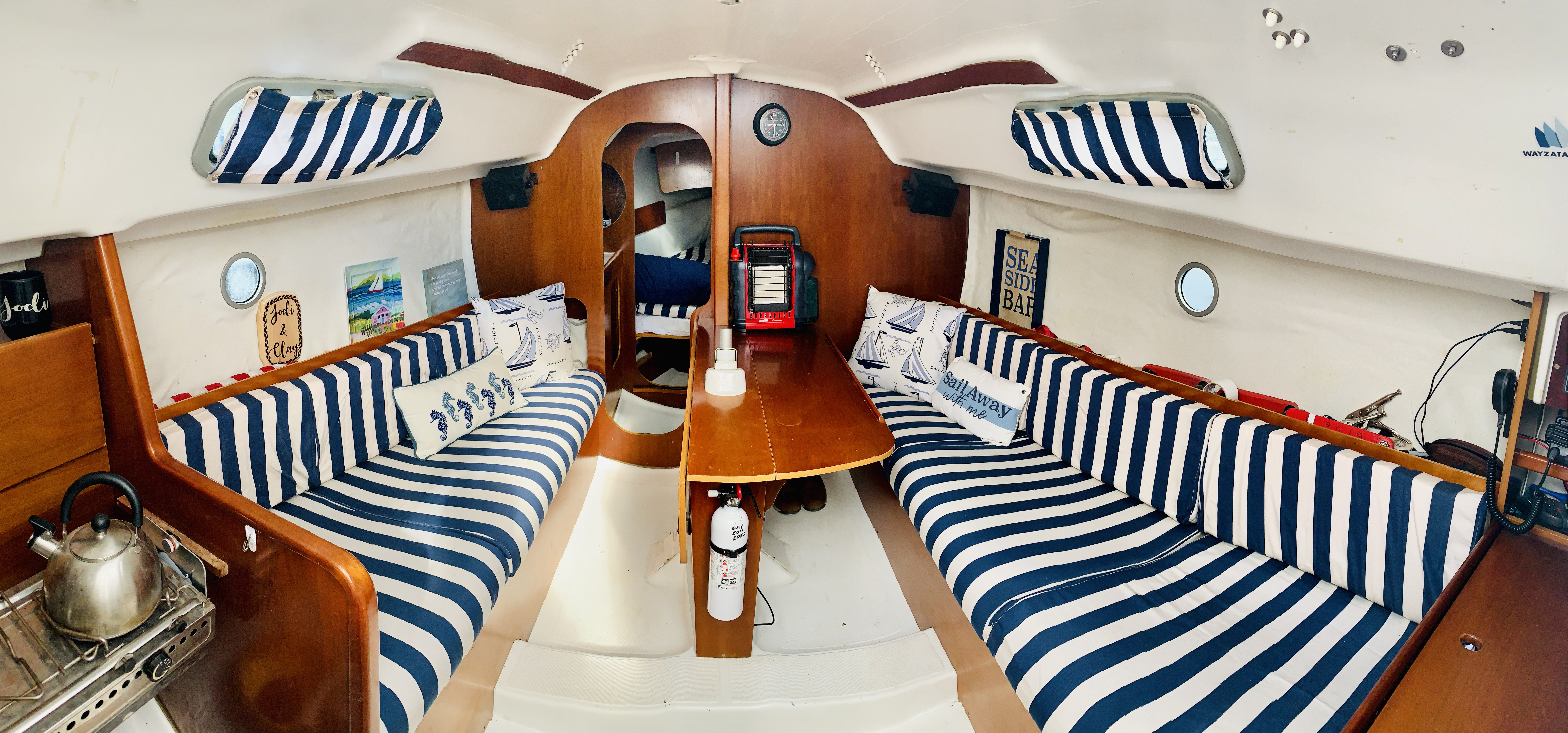 Nautical interior cabin of BlueJ sailboat with striped cushions and cozy seating