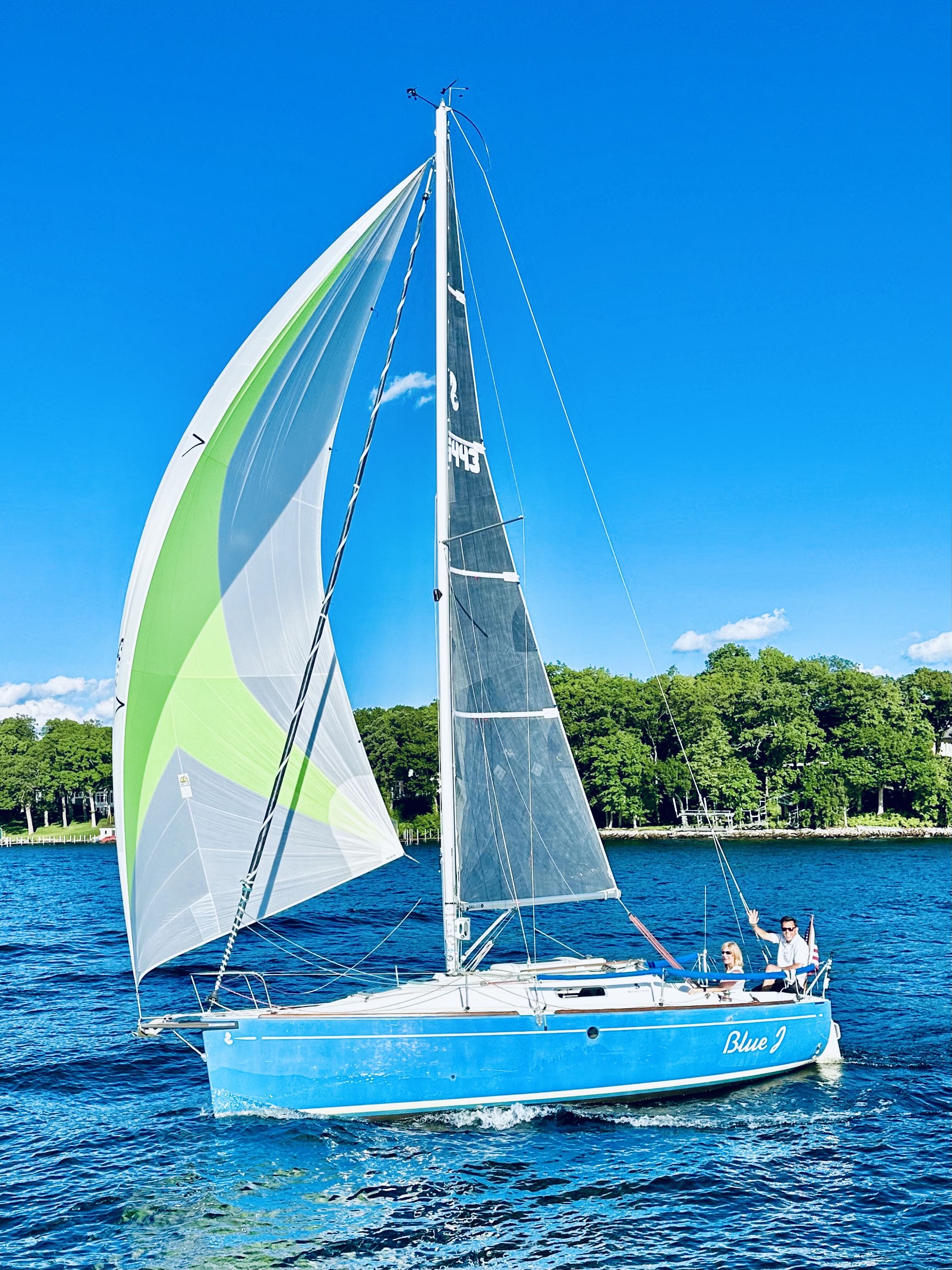 BlueJ sailing charter Lake Minnetonka with colorful green and white spinnaker sail